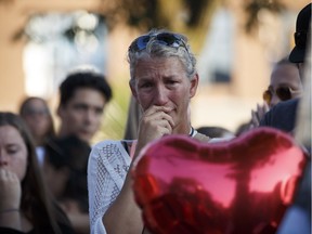 A woman is overcome with emotion as she stands at a vigil for victims of the July 22 mass shooting in Toronto.