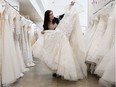 Store manager Diana Gignac displays a wedding dress at Novelle Bridal Shop, 10553 124 St., in Edmonton on Wednesday,  June 27, 2018.