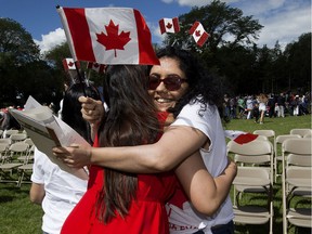 New Canadian citizen Megha Sharma (left) is hugged by a supporter, following Sharma's Canada Day citizenship ceremony at the Alberta Legislature, in Edmonton Sunday July 1, 2018. Photo by David Bloom For a Dustin Cook story running July 2, 2018.