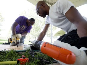 Ibrahima Cisse, left, and Nambe Diarrassouba work to set up the Cote d'Ivoire/Ivory Coast Heritage Days pavilion in Edmonton's Hawrelak Park on Monday, July 30, 2018.