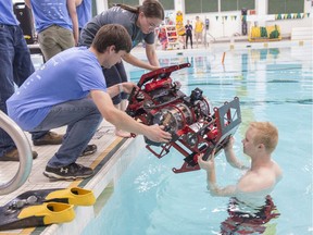 The robotic submarine FAT Auri is lowered into the water to Ryan van Drecht at the Van Vliet pool on Saturday, July 7, 2018.