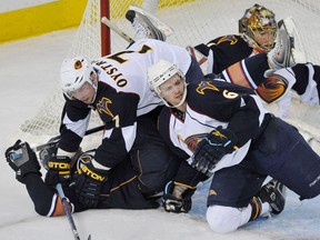 Dustin Penner of the Edmonton Oilers is taken down by Nathan Oystrick and Ron Hainsey of the Atlanta Thashers on March 12, 2009, in NHL action at Rexall Place in Edmonton.