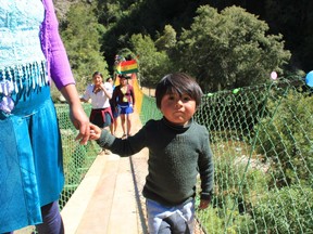 A young child walks across a concrete bridge in a small community in Bolivia that was built with the help of several Edmonton engineering students.