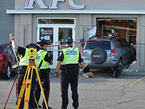 Police investigate at the scene of a vehicle that crashed into a KFC, sending one person to hospital at 156 Street near 87 Avenue in Edmonton on Wednesday, July 18, 2018