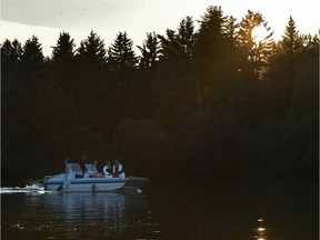 A crew on the lake adding chlorine to the water in preparation for the swim competition at the ITU World Triathlon which starting Friday at Hawrelak Park in Edmonton, July 24, 2018.