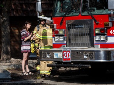 A resident speaks to firefighters at the scene of a fire in the Blue Quill neighbourhood in Edmonton on Sunday, July 29, 2018.