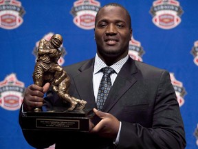 In this Nov. 22, 2012 file photo, B.C. Lions offensive tackle Jovan Olafioye holds the trophy for Most Outstanding Offensive Lineman at the CFL awards show in Toronto.