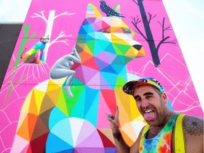 Okuda San Miguel up in the skylift in front of his new mural in Old Strathcona on Monday, July 16, 2018.