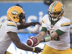 Edmonton Eskimos quarterback Mike Reilly, right, hands off to C.J. Gable during first half CFL football action against the Montreal Alouettes in Montreal on July 26, 2018.
