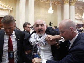 A man is shoved out of the room after showing prior to a press conference after the meeting of U.S. President Donald Trump and Russian President Vladimir Putin at the Presidential Palace in Helsinki, Finland, Monday, July 16, 2018.