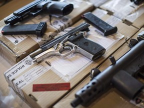 Police display guns seized during a series of raids at a press conference in Toronto on Friday, June 14, 2013.