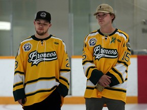 Humboldt Broncos bus crash survivors Derek Patter, left, and Tyler Smith take part in a ceremonial puck drop on Friday at Mark Messier Arena in St. Albert during a ceremony to kick off a memorial hockey tournament organized by friends of four Humboldt Broncos hockey players from St. Albert killed in a tragic bus crash — Stephen Wack, Jaxon Joseph, Logan Hunter and Conner Lukan.