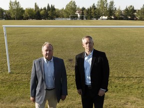 Ernie Kimak (left), president of the Whitemud Creek Homeowners Assocation, and community member Rob McDonald pose for a photo at the Ogilvie Ridge surplus school site in Edmonton, on Thursday, July 12, 2018.