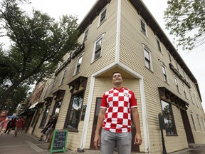 Developer Ivan Beljan poses for a photo in his Croatian jersey infront of the now sold Strathcona Hotel at 10302 82 Avenue in Edmonton, on Friday, July 13, 2018. His company Beljan Development is planning a redevelopment of the historic building. Photo by Ian Kucerak/Postmedia