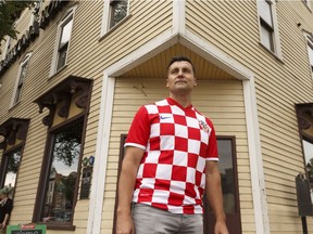 Developer Ivan Beljan wears a Croatia soccer jersey in front of his next restoration project, the Strathcona Hotel.