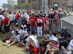 People rest in the shade during the Canada Day noon show on Parliament Hill in Ottawa on Sunday, July 1, 2018. Environment Canada has issued a warning for an extreme heat event, with temperatures in the mid thirties and humidex values into the mid forties.