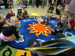 Children listen to a story as the Edmonton Eskimos football club helped kick of the Edmonton Public Library’s (EPL) summer reading club at the EPL Highlands Branch on Wednesday July 4, 2018. The football club’s players and cheer team members will participate in library programs across the city in July and August, to encourage children to read throughout the summer. (PHOTO BY LARRY WONG/POSTMEDIA)