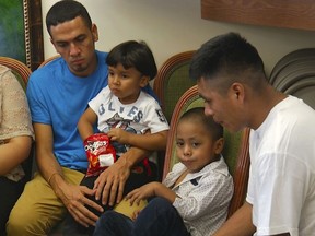 In this image taken from video, Javier Garrido Martinez, left and Alan Garcia, right, sit with their 4-year-sons at a news conference in New York, Wednesday, July 11, 2018. They men were reunited with their children after almost two months of separation, Authorities took their boys them when they stopped at the U.S. southern border.