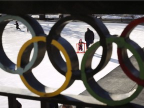 A young girl learns to skate on the ice at the Calgary Olympic Plaza.