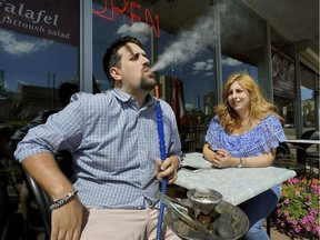 Joe Makarem and Lily Ghazal smoke shisha on the outdoor patio at Edmonton's Co Co Di restaurant.