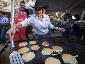 Alberta Premier Rachel Notley cooks pancakes as she attends her annual Stampede breakfast in Calgary on Monday, July 9, 2018.