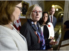 Minister of Crown-Indigenous Relations and Northern Affairs Carolyn Bennett, speaks to reporters about the government's framework for the recognition and implementation of Indigenous rights, as Minister of Indigenous Services Jane Philpott, left, Minister of Justice and Attorney General of Canada Jody Wilson-Raybould, and Minister of Families, Children and Social Development Jean-Yves Duclos look on, in in the House of Commons on Parliament Hill in Ottawa on Wednesday, Feb. 14, 2018.