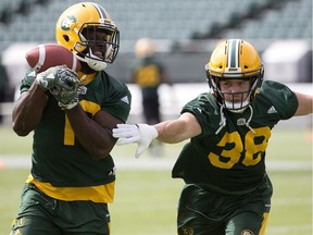 Linebackers Christophe Mulumba-Tshimanga, left, and Adam Konar run a play during Edmonton Eskimos practice at Commonwealth Stadium on Aug. 21, 2017.