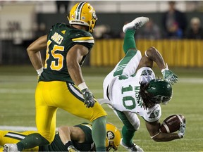 Edmonton Eskimos' J.C. Sheritt (47) and Korey Jones (45) tackle the Saskatchewan Roughriders' Tre Mason (10) during second half CFL action at Commonwealth Stadium, in Edmonton Thursday Aug. 2, 2018. The Eskimos won 26 to 19.