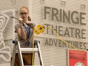 Rae McCallum sets up lighting around the beer garden as crews prepare for the start of the Edmonton Fringe Festival, Wednesday Aug. 15, 2018. Photo by David Bloom