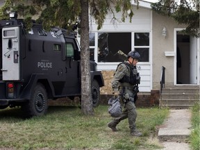 A police office walks past the scene of a shooting and standoff at a home at 12706 76 Street, in Edmonton Thursday Aug. 23, 2018. Photo by David Bloom