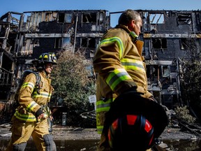 Firefighters investigate at the scene of a fire in the Blue Quill neighbourhood in Edmonton on Sunday, July 29, 2018.