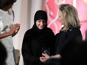 Political activist Samar Badawi (C) of Saudi Arabia is presented with an International Women of Courage Award by U.S. Secretary of State Hillary Clinton (R) as first lady Michelle Obama looks on during a ceremony at the State Department March 8, 2012 in Washington, DC.