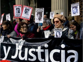 Human Rights activists holding pictures of missing people take part in a protest outside the Chilean Supreme Court in Santiago, against the release of  several agents of Augusto Pinochet's dictatorship (1973-1990), convicted for human rights violations, on August 01, 2018. The Chilean Supreme Court granted conditional freedom to five repressors who acted during Pinochet's dictatorship.