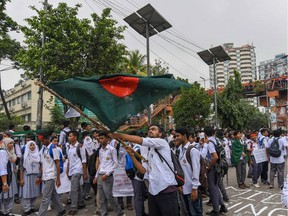 A Bangladeshi student waves Bangladesh's national flag as they block a road during a student protest in Dhaka on Aug. 4, 2018. Calls for greater road safety were made after  two teenagers were killed by a speeding bus.