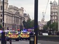 This grab taken from a video posted by Twitter user EwelinaUO shows armed police surrounding a silver car after it crashed into barriers outside the Houses of Parliament on August 14, 2018 in central London.