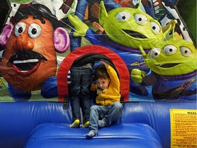 Joseph Bernabei, 3, right, and his brother Frank Bernabei, 5, play on the bouncy castle at the Children's Autism Services of Edmonton annual family back-to-school barbecue on Saturday, Aug. 25, 2018.