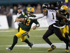 Edmonton Eskimos quarterback Mike Reilly (13) runs against the Hamilton Tiger-Cats during second quarter CFL action on Friday, June 22, 2018 in Edmonton.