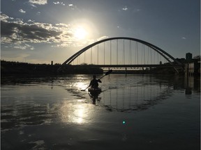 Kristina Givens paddles her kayak on the North Saskatchewan River in Edmonton, with the new bridge in the background on May 6, 2018.