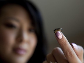 Jennifer Chae, a beauty blogger from Kansas City, shows off an Asian style circle lens on the tip of her finger in Overland Park, Kan., June 15, 2010.