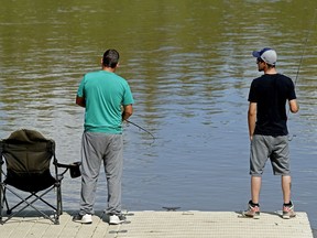 Chris Fouquette (left) and his nephew Brandon Fouquette fish off a boat dock near the Dawson Bridge in Edmonton on Sunday July 8, 2018 during the final license free fishing weekend of the year, which occurs twice a year in Alberta.