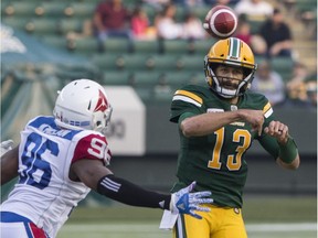 Edmonton Eskimos Mike Reilly (13) passes the ball as Montreal Alouettes Vantrel McMillan (96) zeroes in during CFL action in Edmonton on Aug. 18, 2018.