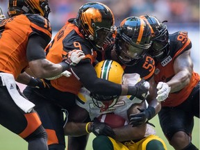 B.C. Lions' Shawn Lemon (9), Jordan Herdman (53) and Davon Coleman (90) tackle Edmonton Eskimos' C.J. Gable, front, during first half CFL football action in Vancouver on Aug. 9, 2018.