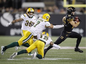 Hamilton Tiger-Cats receiver Luke Tasker runs for a touchdown past Edmonton Eskimos' Josh Woodman, left, and Forrest Hightower, centre, during the second half of CFL action in Hamilton on Aug. 23, 2018.