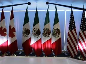 National flags representing Canada, Mexico, and the U.S. are lit by stage lights at the North American Free Trade Agreement, NAFTA, renegotiations, in Mexico City, Tuesday, Sept. 5, 2017. Donald Trump's administration is giving Canada until Friday to sign onto a bilateral trade deal between the U.S. and Mexico or be treated as "a real outsider" against whom punishing tariffs on autos will be imposed.