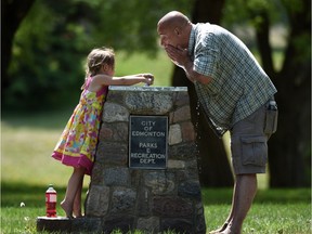 Nakiea Zettel, 4, and her uncle Steve Pellatt cool off with the drinking fountain in Emily Murphy Park on Monday May 25, 2015.