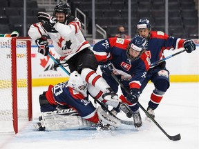 Canada's Bowen Byram (4) is shoved by Slovakia's Frantisek Gajdos (26) into goaltender David Borak (30) during first period Hlinka Gretzky Cup action in Edmonton on Aug. 7, 2018.