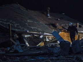 Investigators go through the remains of a fatal house explosion as light fades on Sunday, Aug. 26, 2018 in the Paso Estates subdivision at Range Road 224 and Township Road 513 near Cooking Lake southeast of Sherwood Park. One woman is dead and a man was badly injured.