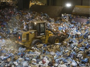 An equipment operator uses a front end loader in the recycling building at Edmonton Waste Management Centre in Edmonton, Alberta on Wednesday, December 27, 2017.