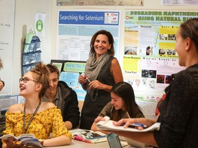 Bishop Carroll High School physics teacher Laurie O'Connor is surrounded by students Grace O'Connor, 17, left, Anna Krupp, 15, David Svoboda, 17, Emily Wood, 16, and Kayla McArthur, 16, on June 13, 2018. Teachers in Alberta are about to start negotiating a new contract because the current contract expires on Aug. 31, 2018.