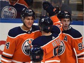 Edmonton Oilers Ethan Bear (74) celebrates his first NHL goal with Ty Rattie (8) and Ryan Nugent-Hopkins (93) against the Anaheim Ducks during NHL action at Rogers Place in Edmonton, March 25, 2018.